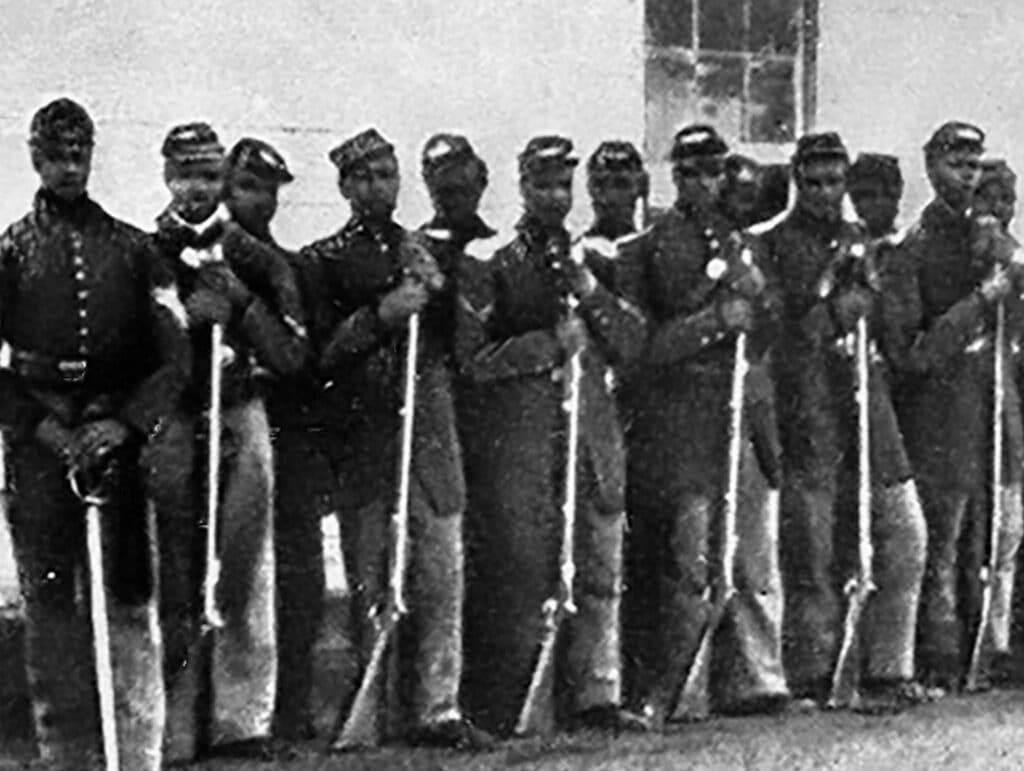 A line of African American Civil War soldiers in uniform, holding rifles and standing at attention.