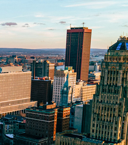 An aerial view of New York City skyline with tall buildings and a clear sky at sunset.