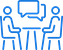 Two outlined figures sitting at a table with a speech bubble above, indicating a conversation or discussion.