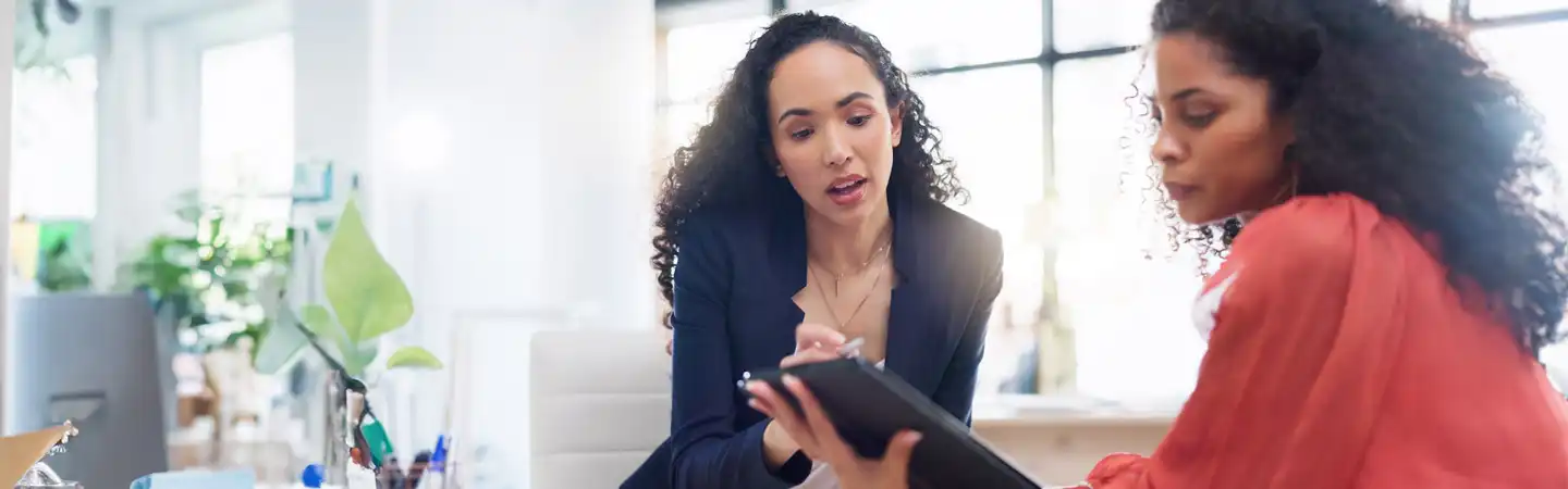 women talking while taking notes