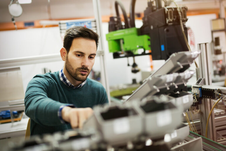 Person operating machinery in an industrial setting, focusing on components and controls.