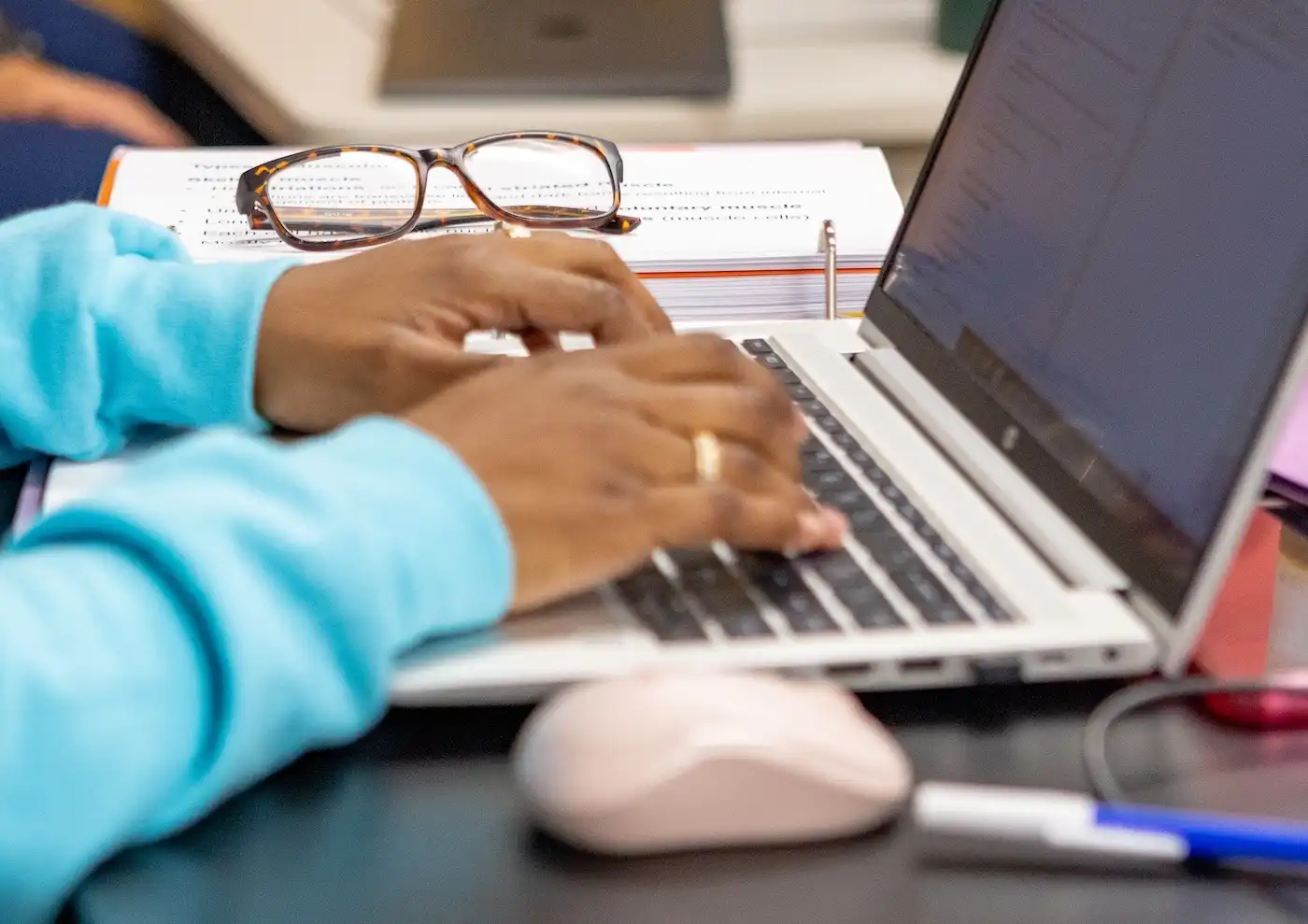 student hands typing on laptop