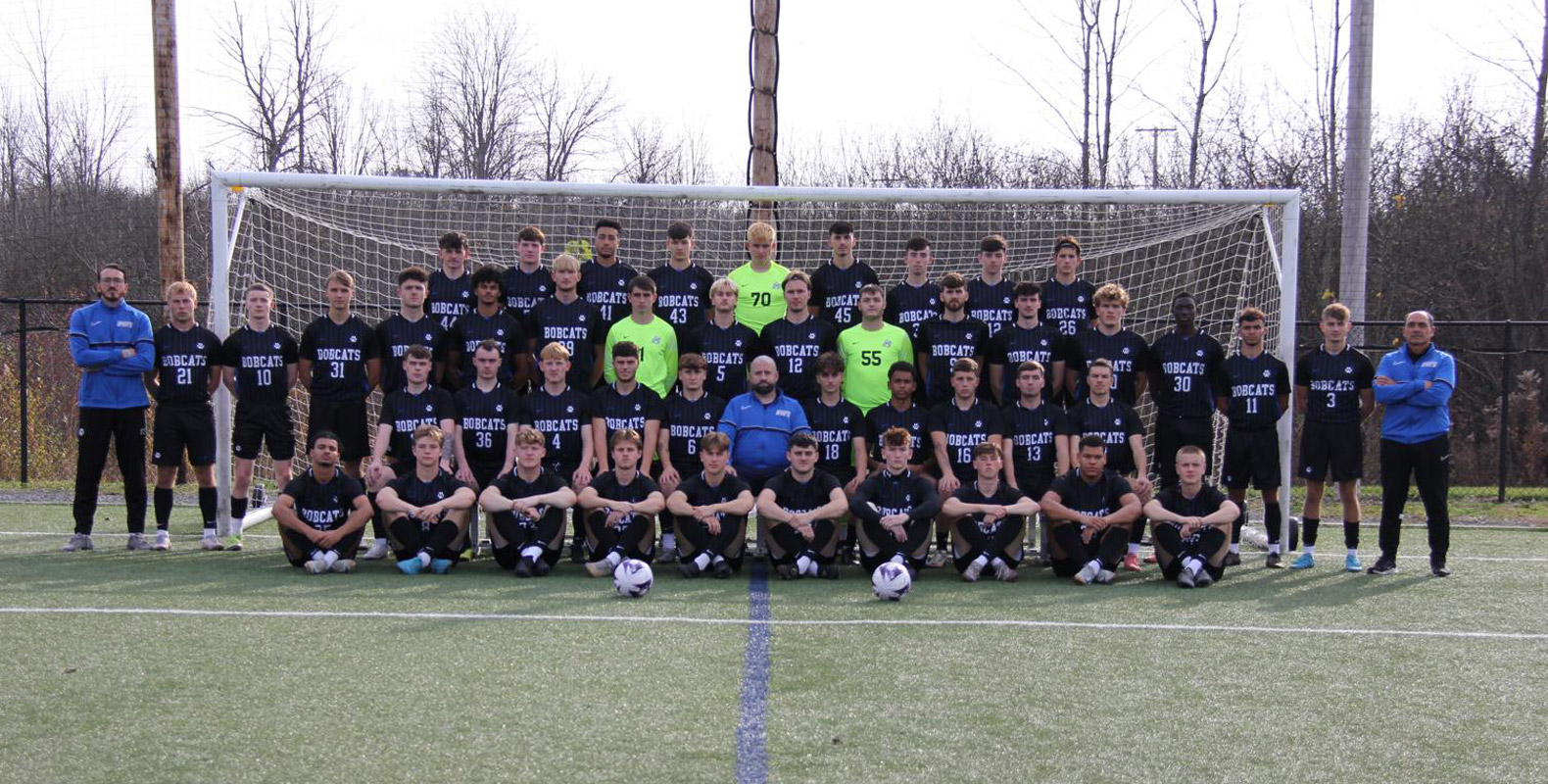 The Bryant & Stratton men's soccer team posing together on a field in front of a goal, wearing 'Bobcats' jerseys.
