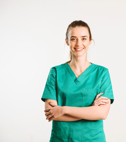 Smiling person wearing green medical scrubs stands with arms crossed against a plain background.