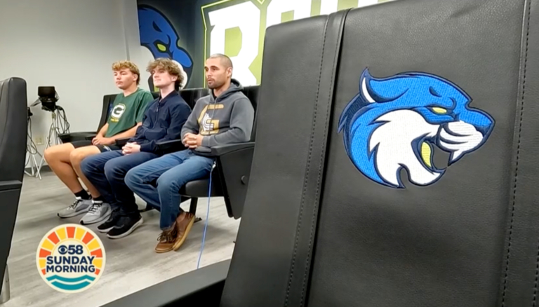 Three people sit in a row of black chairs in a modern room at Bryant & Stratton College’s Buffalo Campus. The chair closest to the camera has a blue wildcat logo, and the "CBS 58 Sunday Morning" logo is visible in the corner.