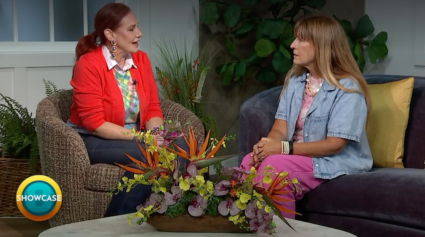Two women sit on a talk show set, engaged in conversation about information technology careers. They are surrounded by plants and a floral arrangement, creating an inviting atmosphere. A “SHOWCASE” logo appears in the corner, highlighting the opportunities available through programs at Bryant & Stratton College.